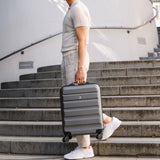 Man carrying Aerolite suitcase on stairs