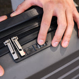 Hands setting TSA lock on Aerolite suitcase